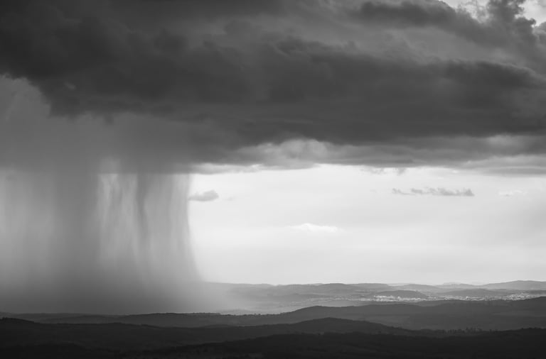 Quadro em preto e branco com fotografia de nuvens de chuva entre as montanhas de Minas Gerais.