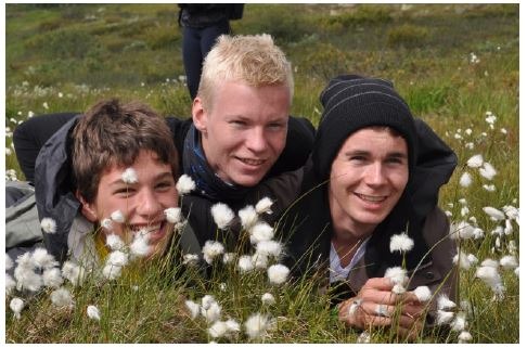 three smiling boys lying in a meadow-Telelaget