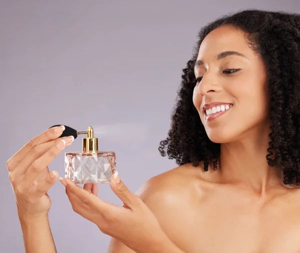 beautiful black woman spritzing perfume