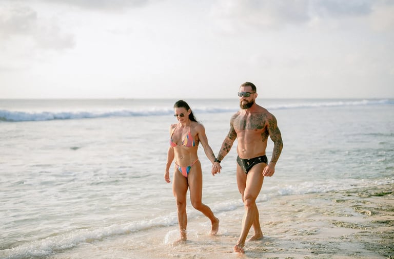 Parents walking together along the shoreline during a relaxed family photography session at Dreamland Beach Bali.