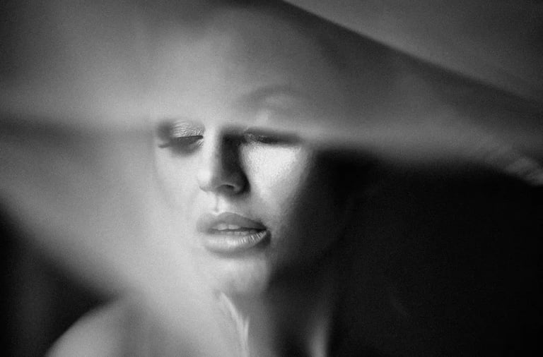 portrait en noir et blanc d'une mariée sous un voile flouté