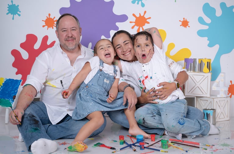 a family posing for a photo in front of a wall with paint splatters