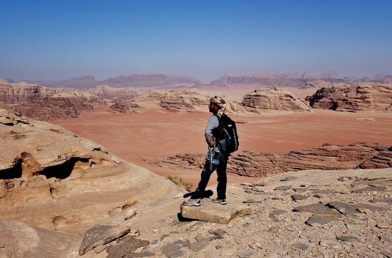 a person standing on a rocky cliff overlooking a valley