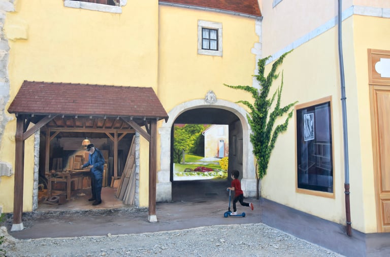 Détails d'une fresque en trompe-l'oeil peinte sur une façade, Un atelier, un enfant en trottinette.