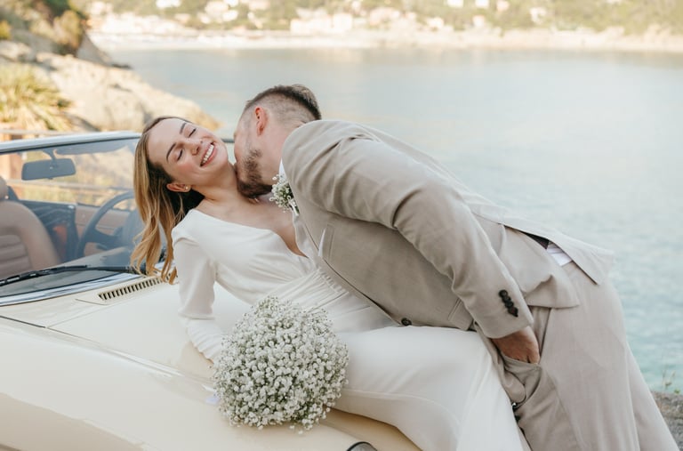 a man and woman kissing in front of a car in Bonassola wedding