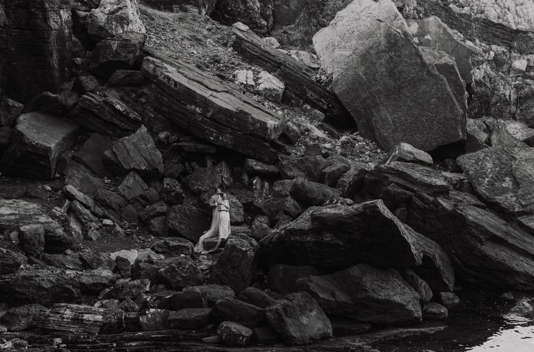 a person standing on a rocky cliff face in Portovenere
