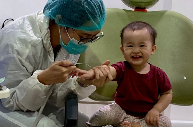 a woman in a surgical mask and a baby in a chair