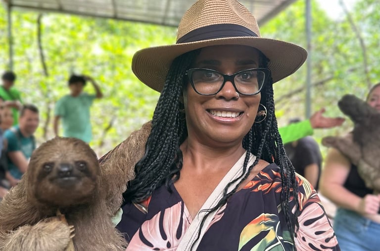 a woman in a hat and a hat holding a sloth - sloth slot