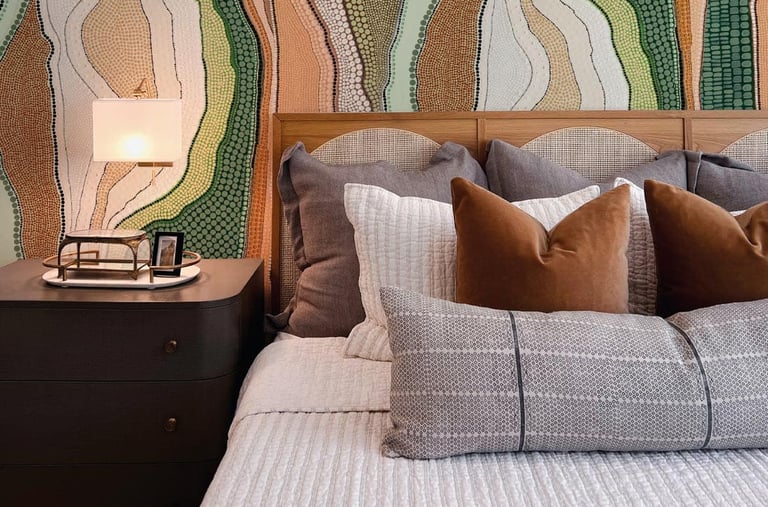 Modern bedroom featuring an earthy Aboriginal dot art wallpaper behind a wooden headboard with neutral bedding.
