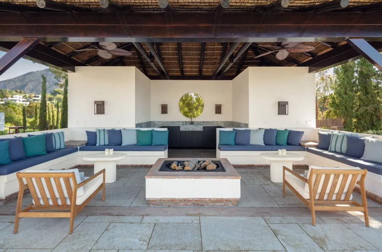Covered outdoor lounge at Villa La Gratitud with fire pit and pool views