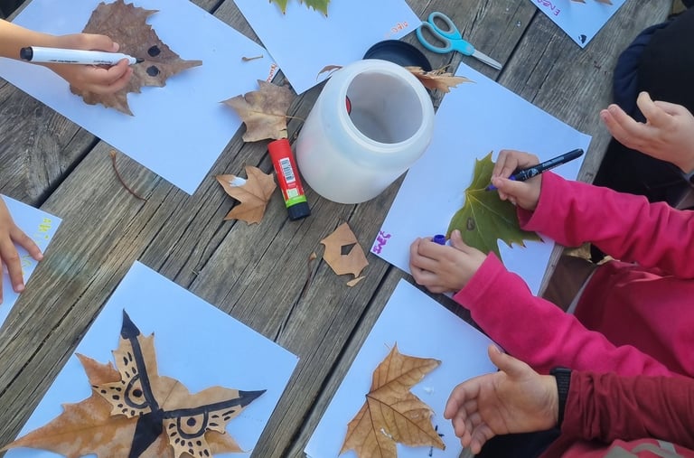 Niños haciendo un taller divertido con hojas secas y aprendiendo acerca de la naturaleza