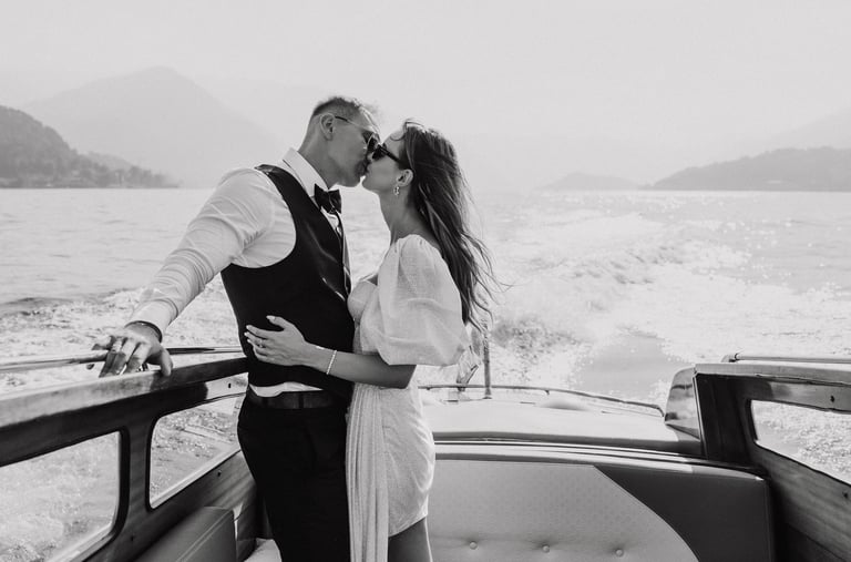 a man and woman kissing on a boat