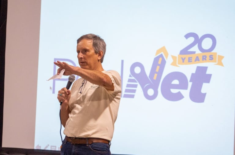 Man with a microphone in front of a presentation screen