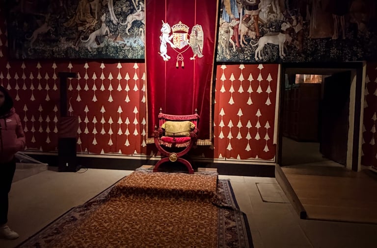 a red chair against a red tapestry and walls