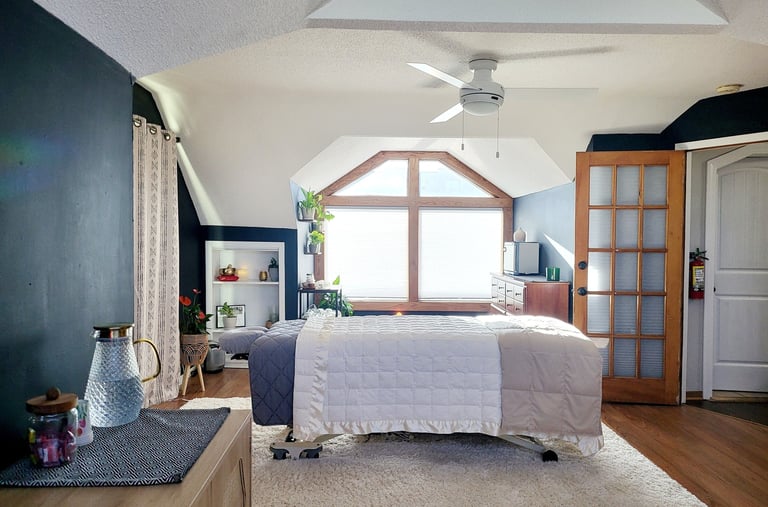 Cozy treatment room with soft lighting and a massage table prepared for a session.