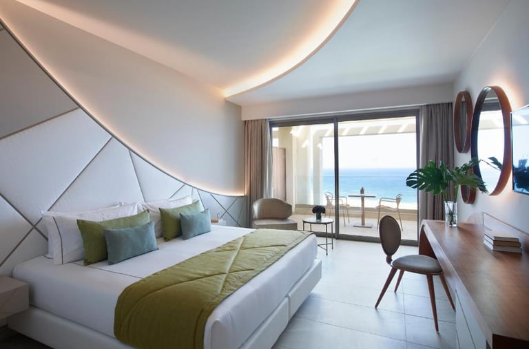 Luxury modern hotel suite with ocean view balcony, king bed, and stylish interior design.