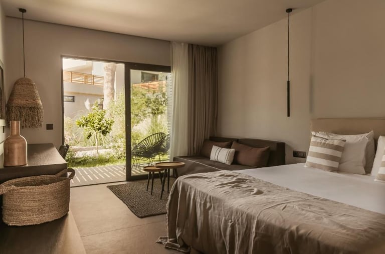 Modern luxury hotel room with king bed, private garden terrace, and minimalist interior design.