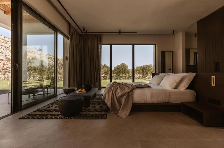 Modern minimalist luxury bedroom with floor-to-ceiling glass doors, organic linens, and desert views.
