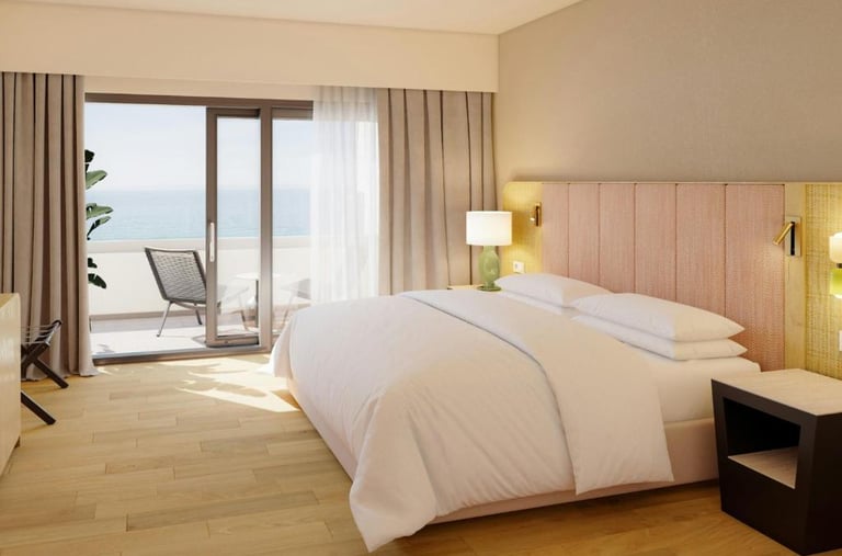 Modern luxury hotel room with a plush double bed, private balcony, and scenic ocean views.
