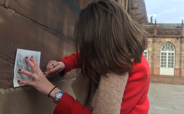 a woman in a red jacket is holding a piece of paper