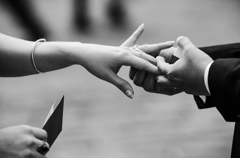 Plano detalle de novio colocándole el anillo a su novia en el dedo