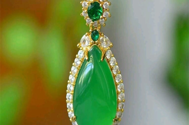 a green necklace with a green tear shaped pendant