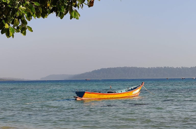Andaman trip details - A colorful traditional boat anchored in the crystal-clear azure waters of Hav