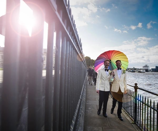 Newly-weds walking alongside the River Thames in Greenwich