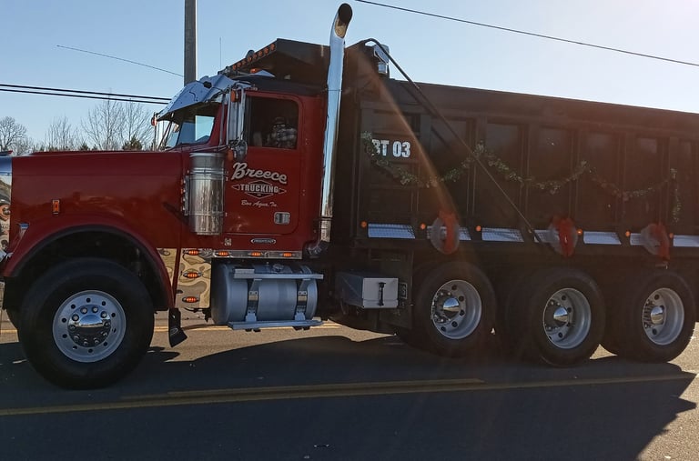Dump Truck riding down the road, trucking services