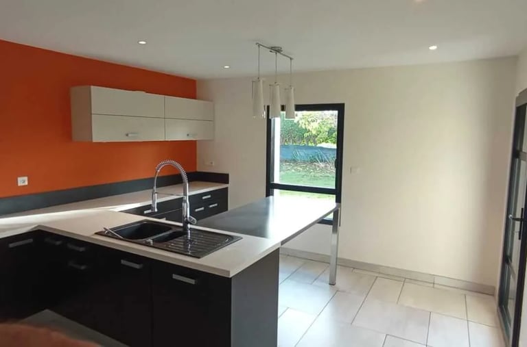 Peinture intérieure d'une cuisine moderne avec mur orange par l'artisan DM Rénovation à Landivisiau