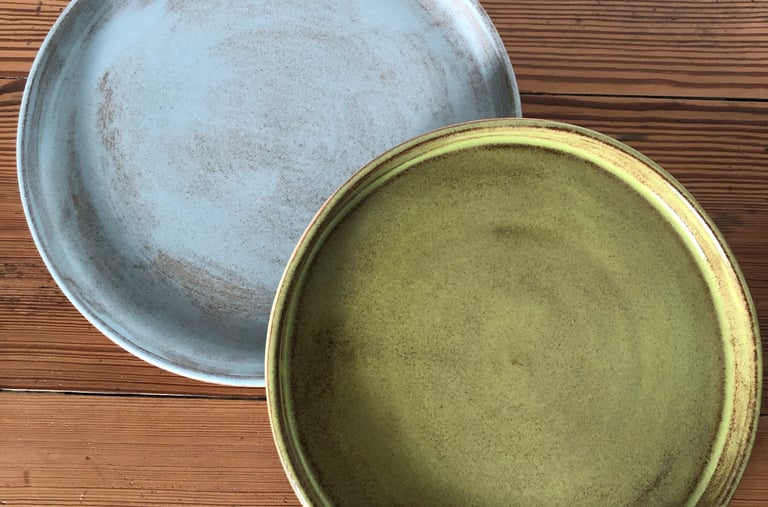 Assiettes en grès, une de couleur verte l'autre en bleu.