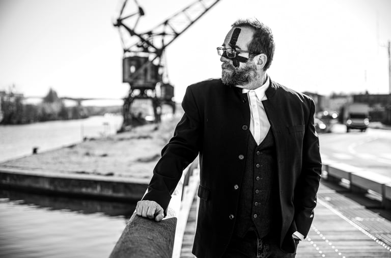 Photographie artistique N&B d'un homme en costume-cravate se tenant sur un quai