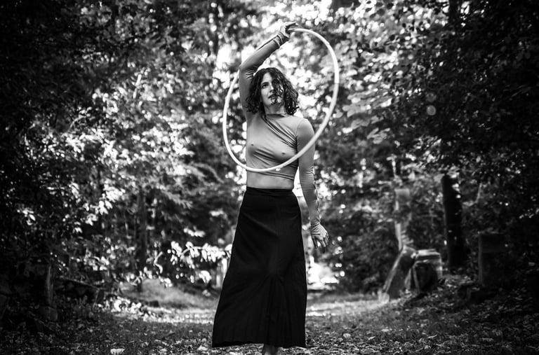 Photographie artistique N&B d'une femme vêtue d'une jupe faisant du cerceau