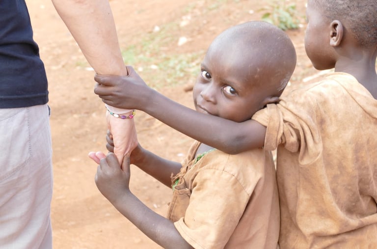 Foto von 2 Kindern, die sich an der Hand eines PH-Mitglieds festhalten