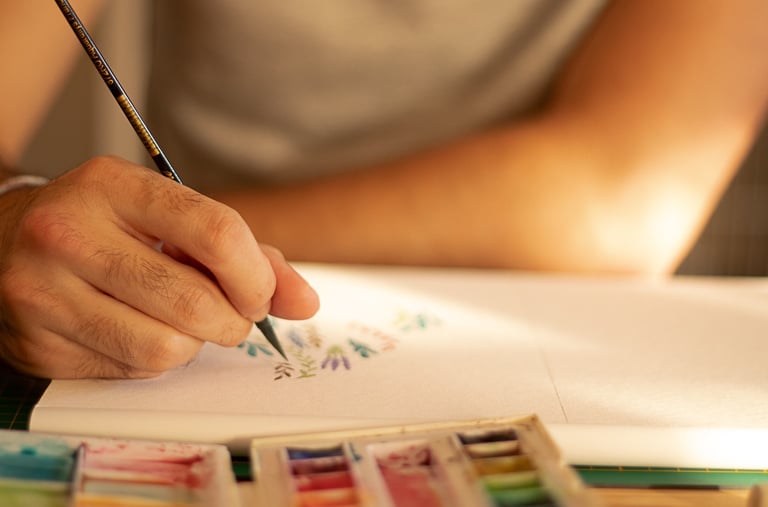 tommy gautier's hand painting some flowers