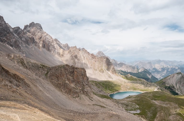 a person standing on a mountain top with a lake in the background