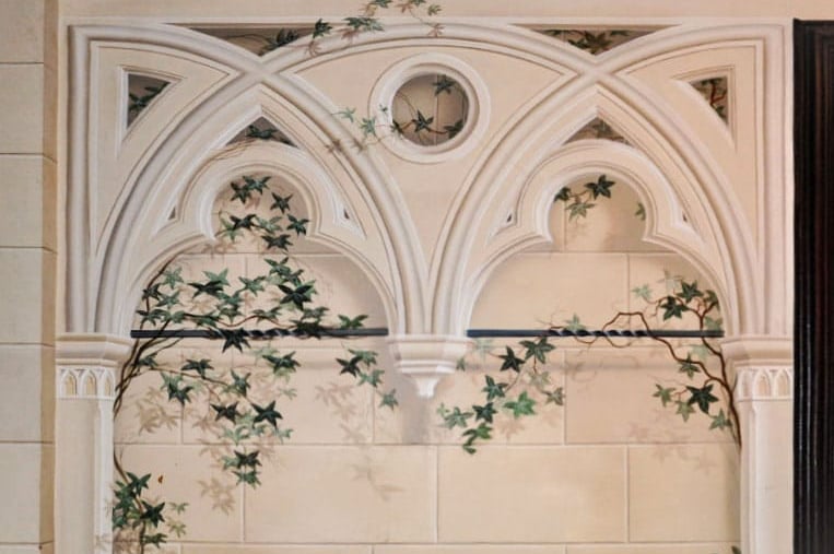 Painted trompe l'oeil gothic arch in a sandstone finish, complete with sandstone blocks in the background and ivy vines.