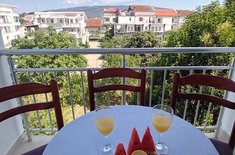 a table with a plate of fruit and glasses of wine
