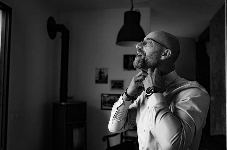 Un homme en chemise blanche remettant son col