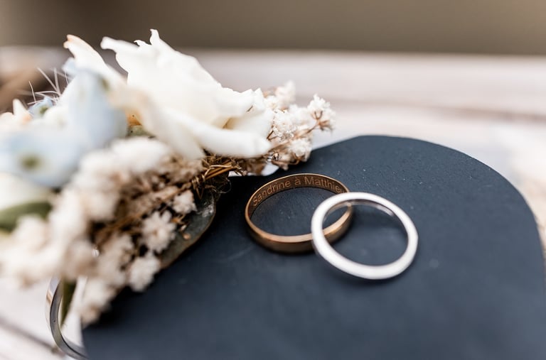 Deux alliances posées l'une sur l'autre près dune composition florale