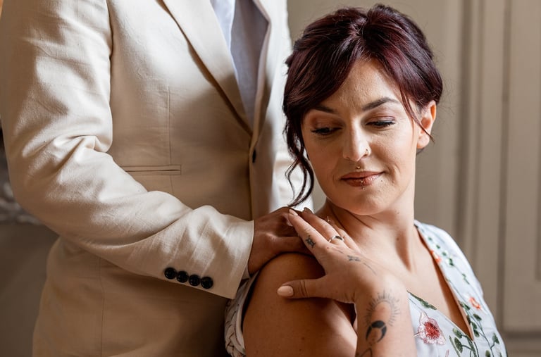 Une homme en costume clair posant sa main sur l'épaule de sa femme