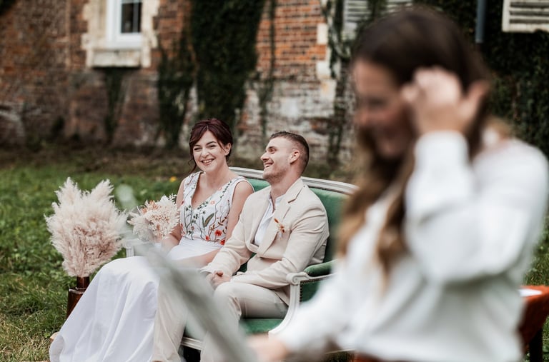 un couple de mariés assis dans un fauteuil pendant leur cérémonie