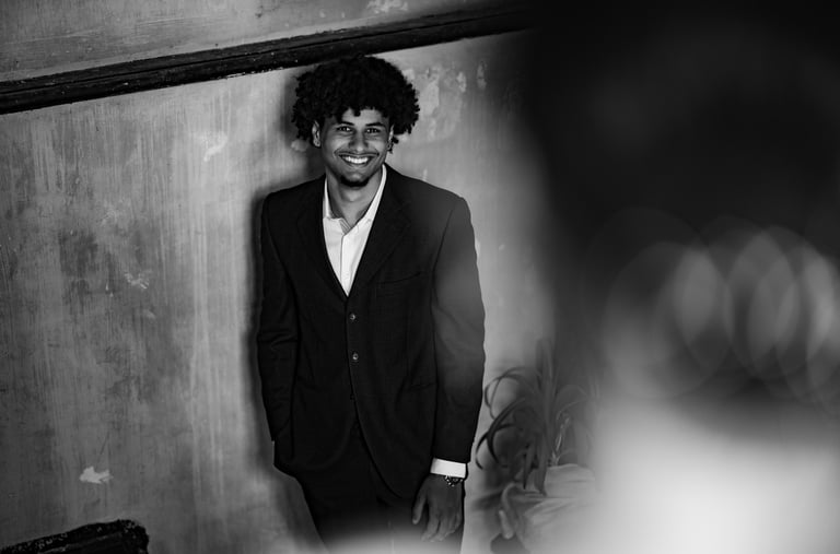 Un homme en costume noir debout souriant