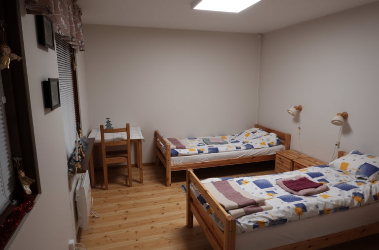 a bedroom with two beds and a desk