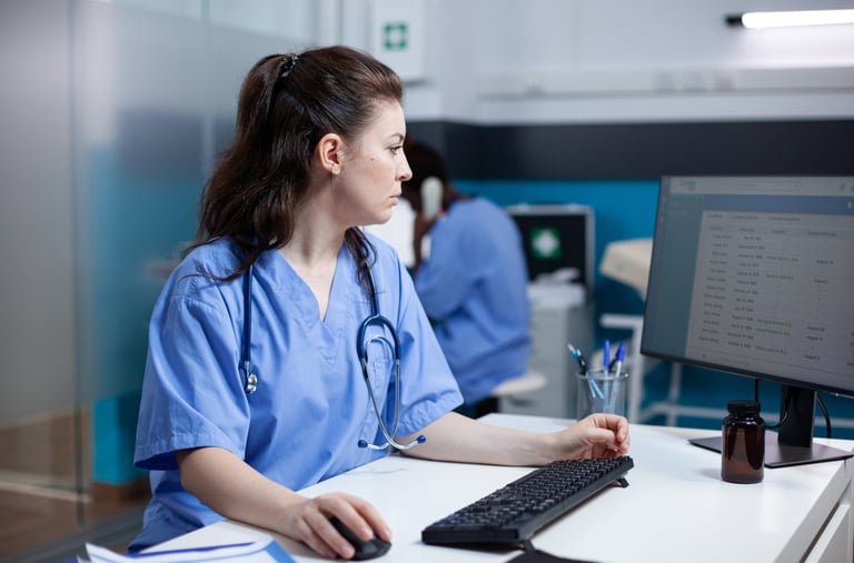 a woman in scrubs and scrubs sitting at a computer