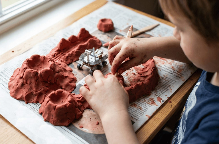 child making planet Mars mountains with playdough