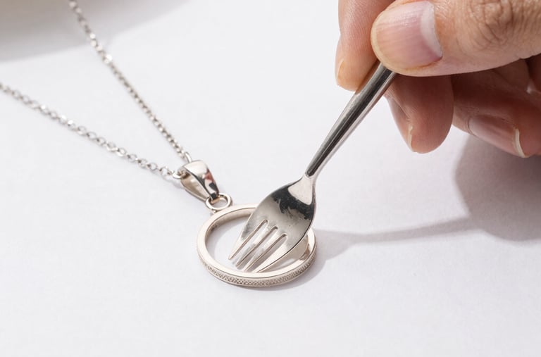 Hands gently cleaning silverware with a soft cloth and silver cleaner.