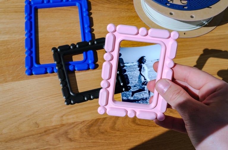 3D printed home decor frame being placed over a photo by hand, customizable personal display object