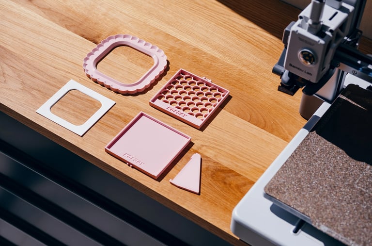3D printed home decor parts on wooden table next to 3D printer, easy print design