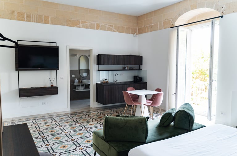 a bedroom with a bed, couch, and television